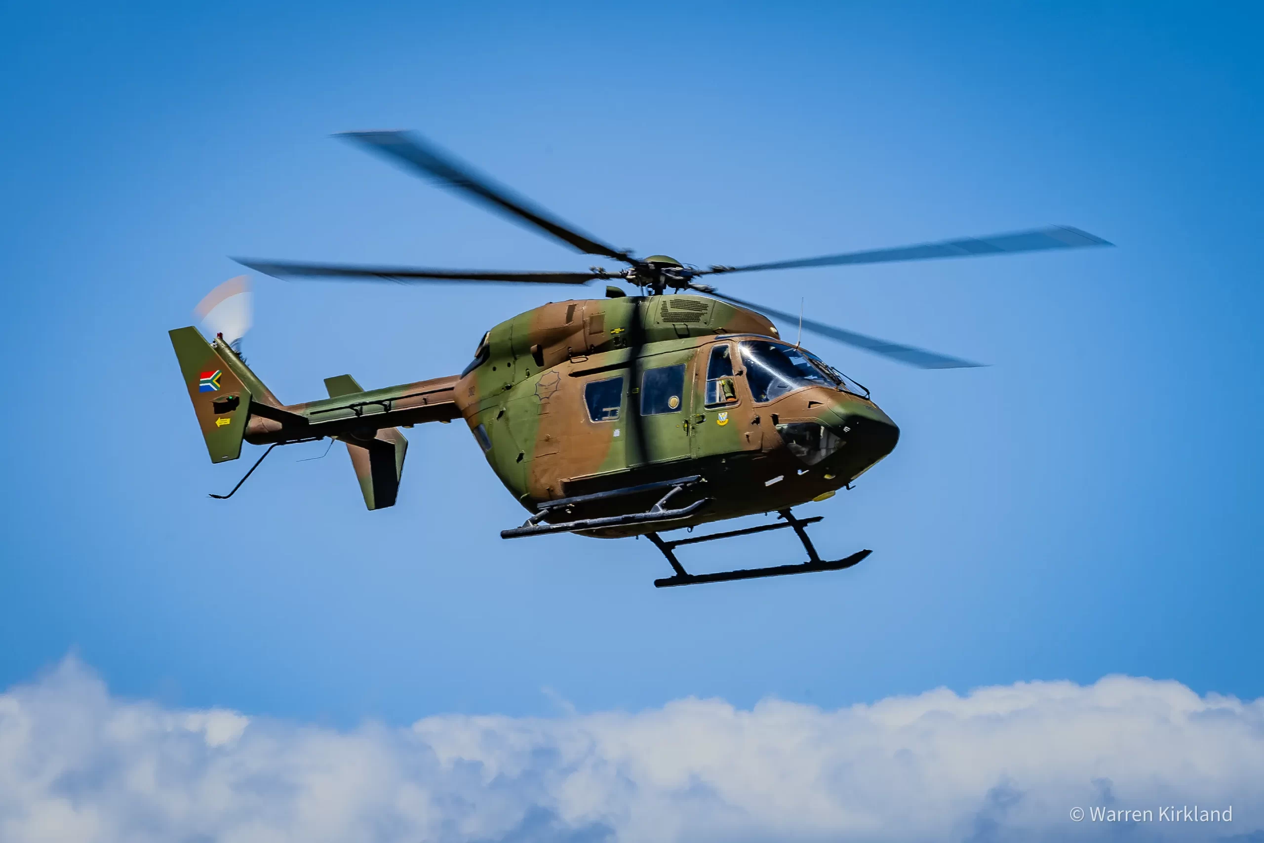 South African Air Force helicopter flying against a blue sky