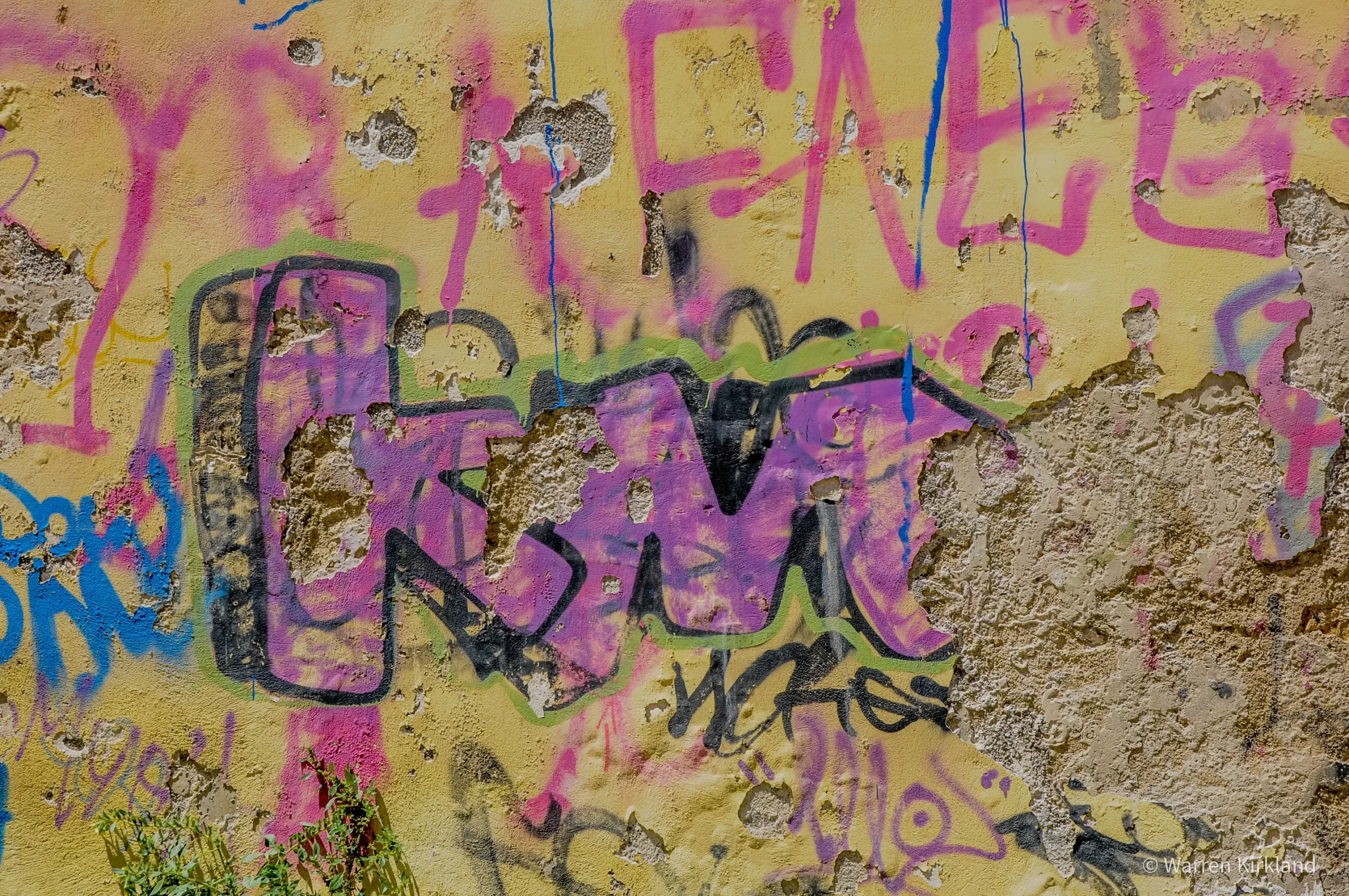 Colourful graffiti tags on a weathered wall