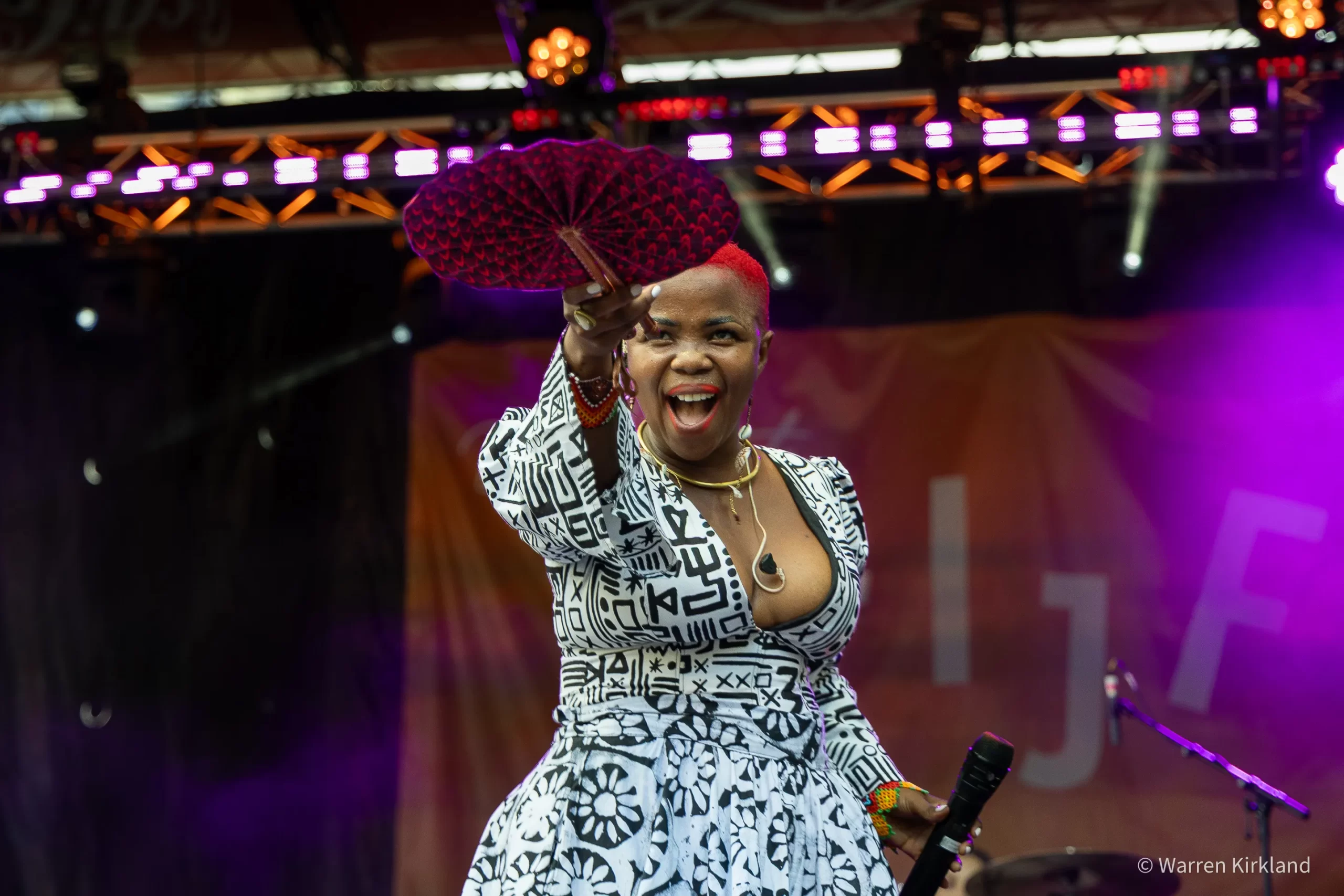 Zonali Mahola performing on stage holding up a decorative fan