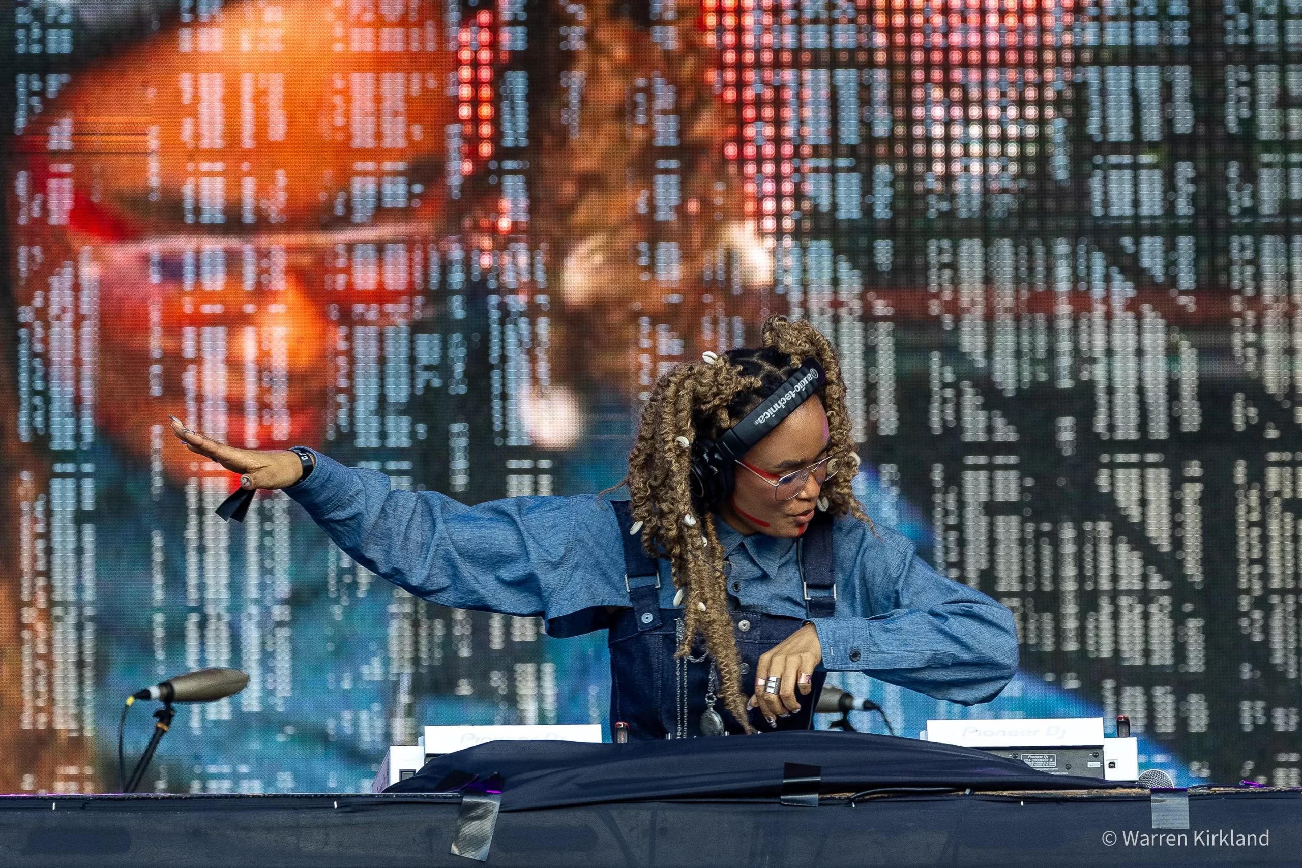 SIO DJing on stage in front of a large LED screen