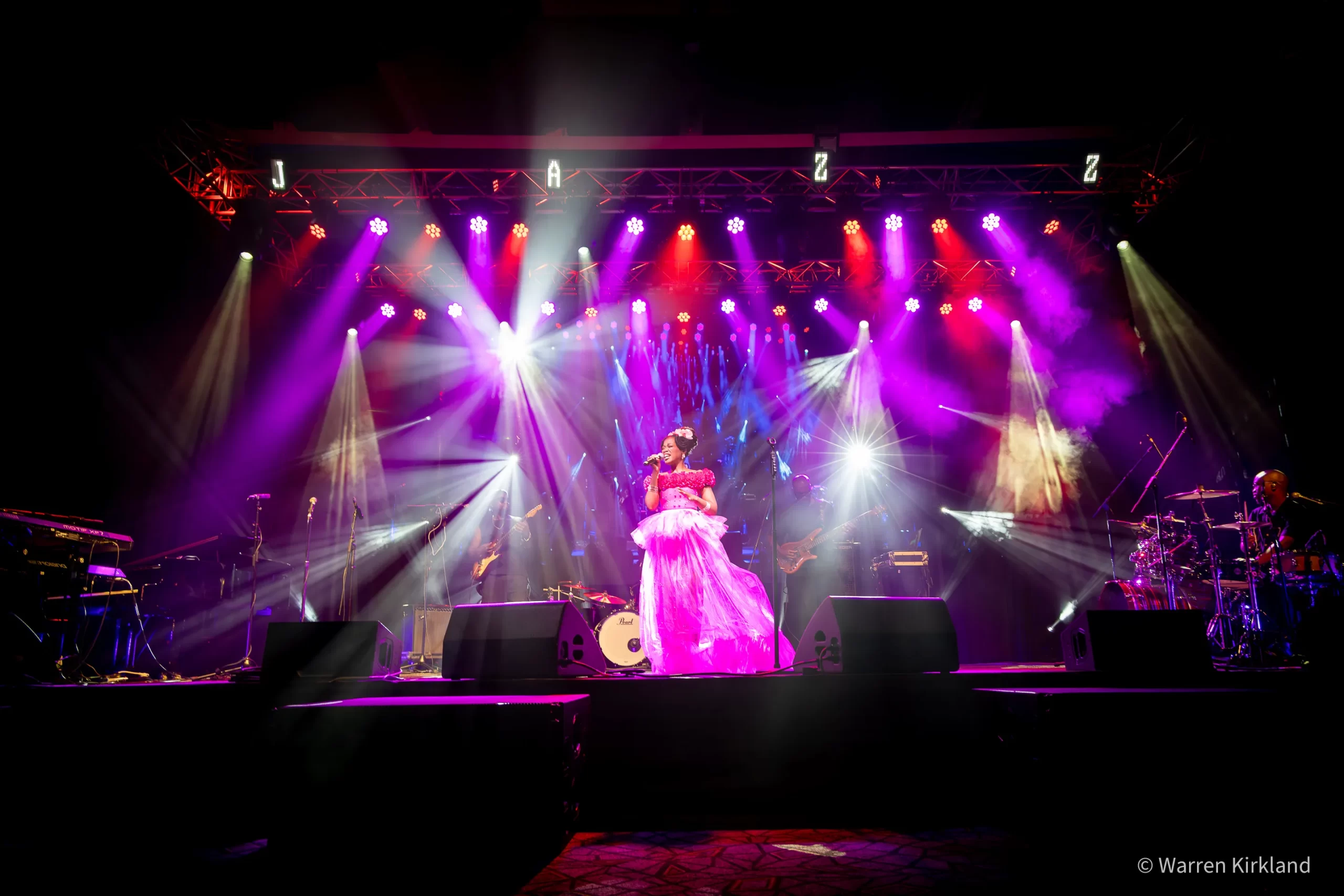 Rorisang Seshele singing on stage under purple and pink lights