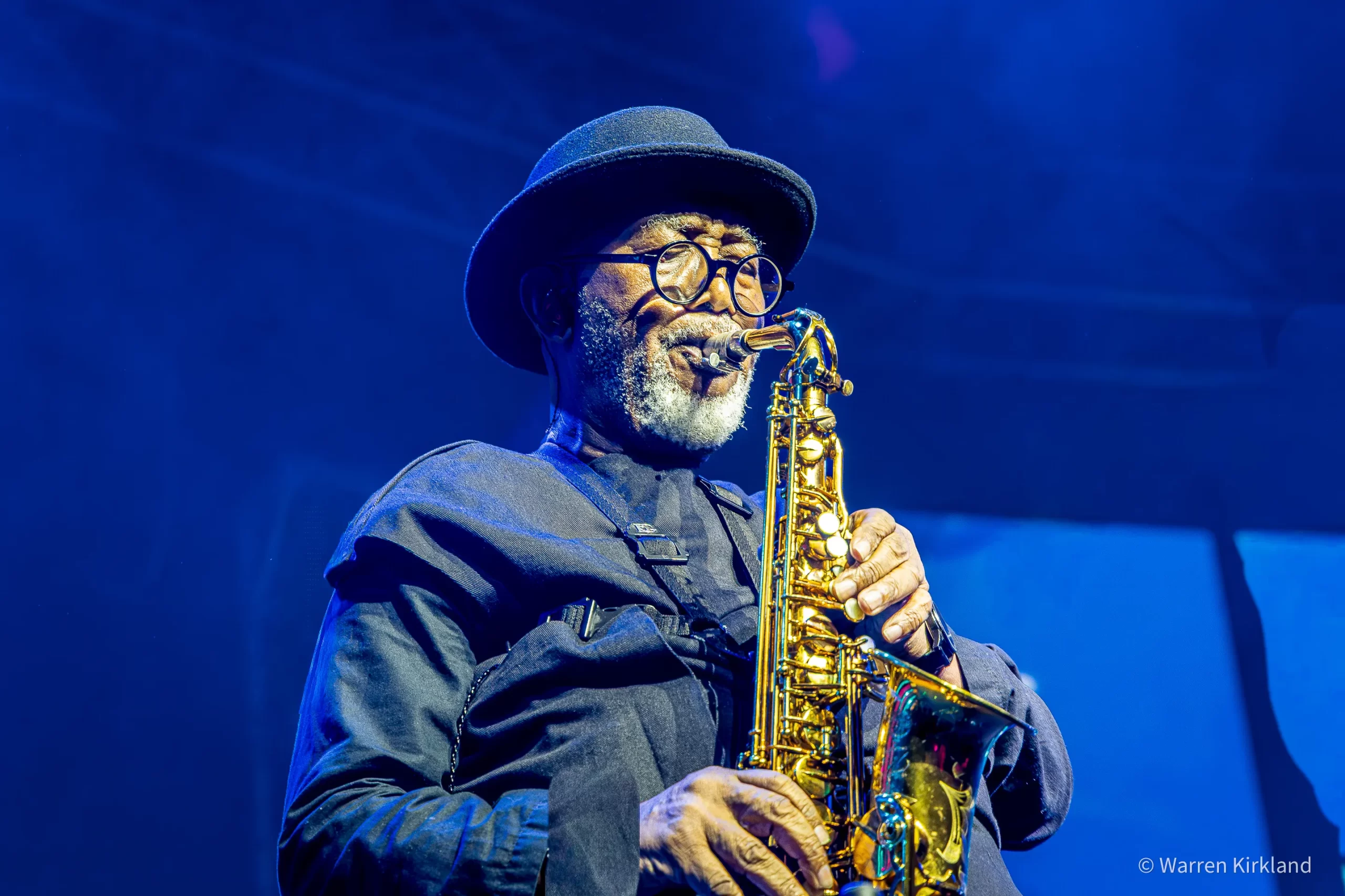 Sipho 'Hotstix' Mabuse playing saxophone under blue stage lights