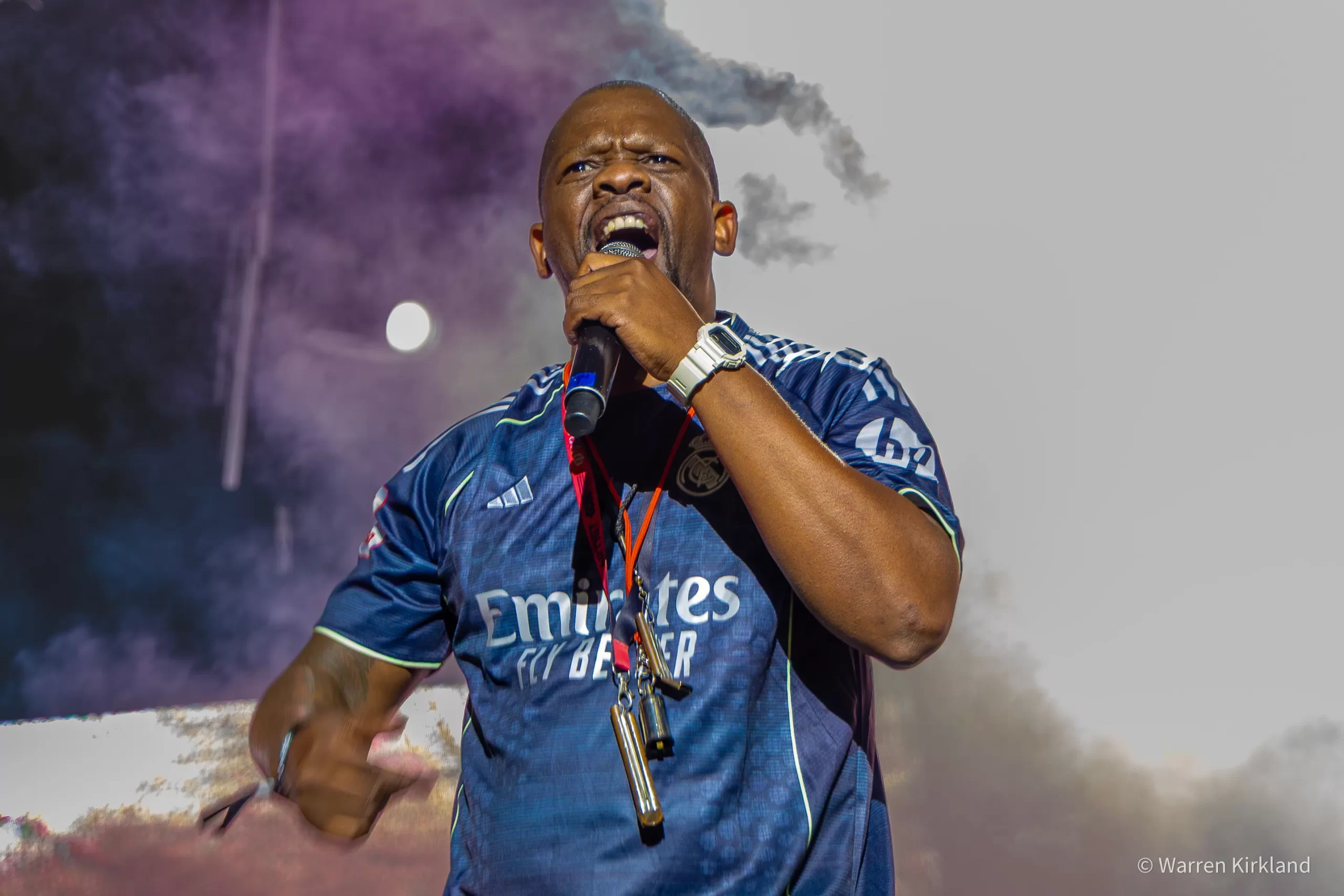 BCUC frontman singing into a microphone amid coloured smoke