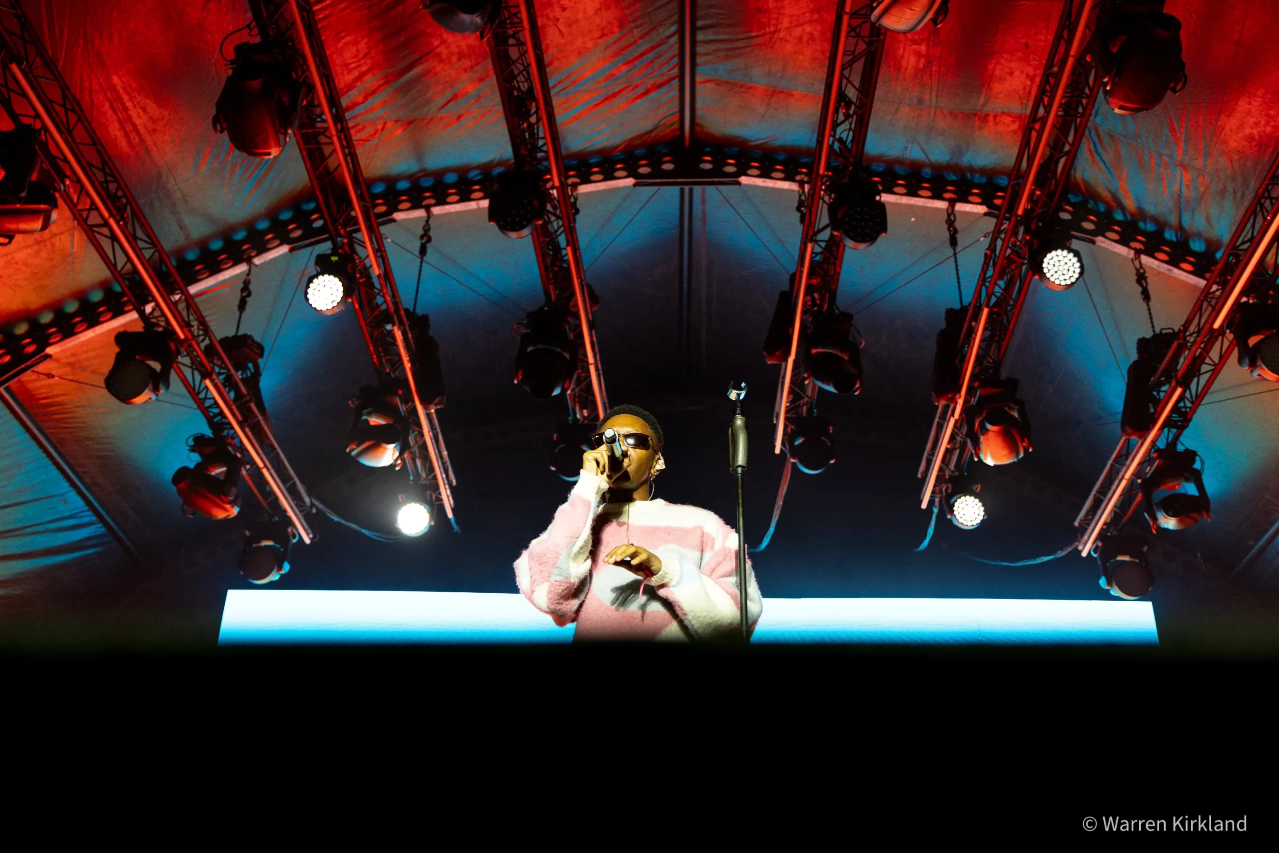 Luukhanyo performing on stage framed by a dramatic lighting rig
