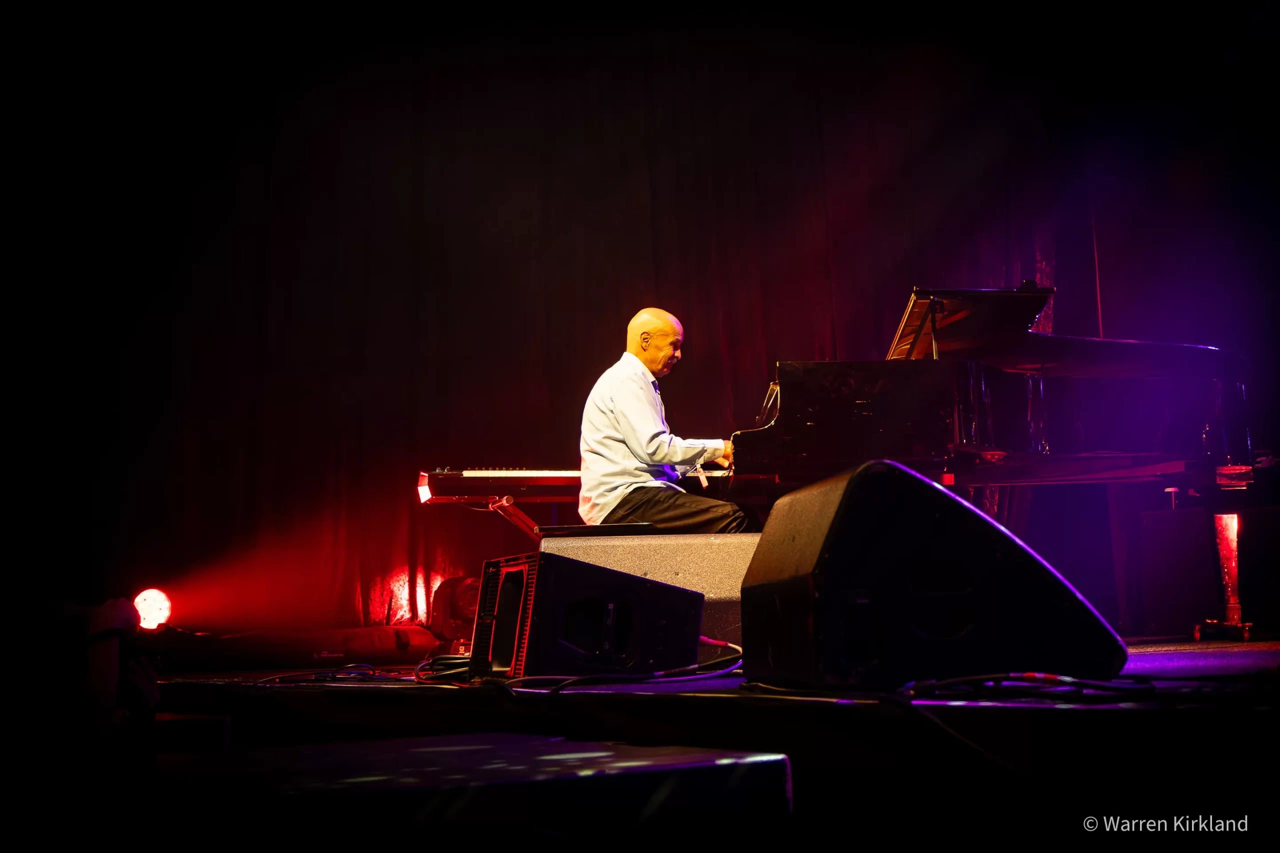 Camissa Knights performing on piano under red stage lights
