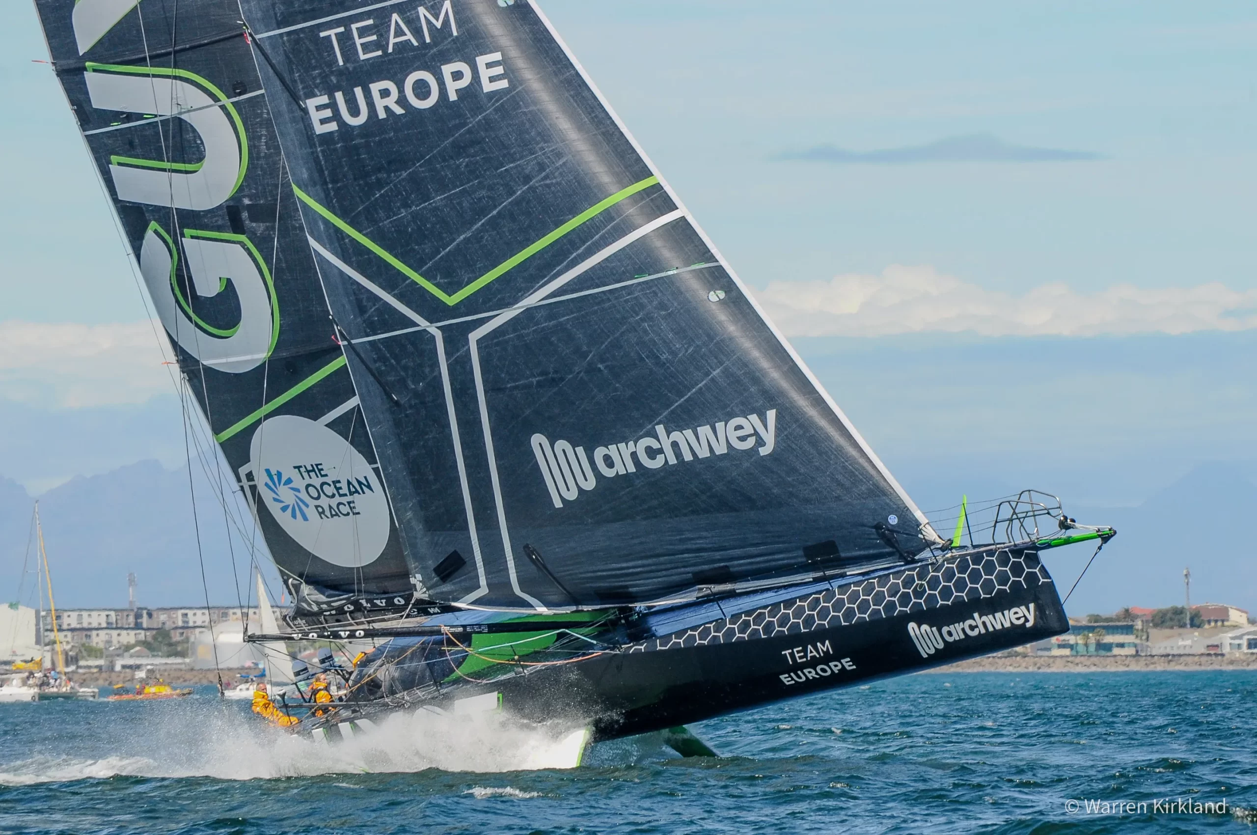 Team Europe yacht heeling steeply with spray off the bow, The Ocean Race