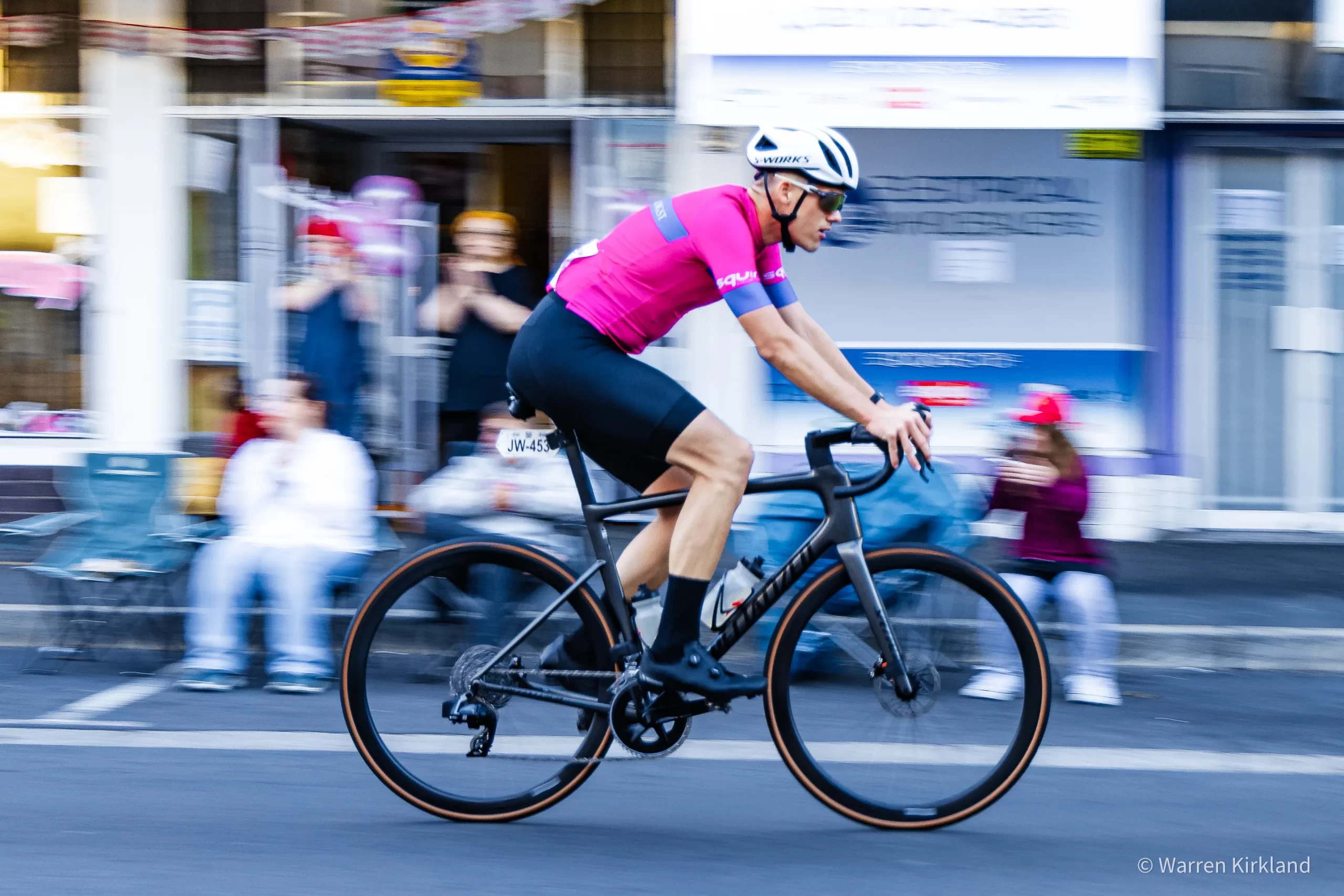 Cyclist riding through a city street with motion-blurred background, Cape Town Cycle Tour