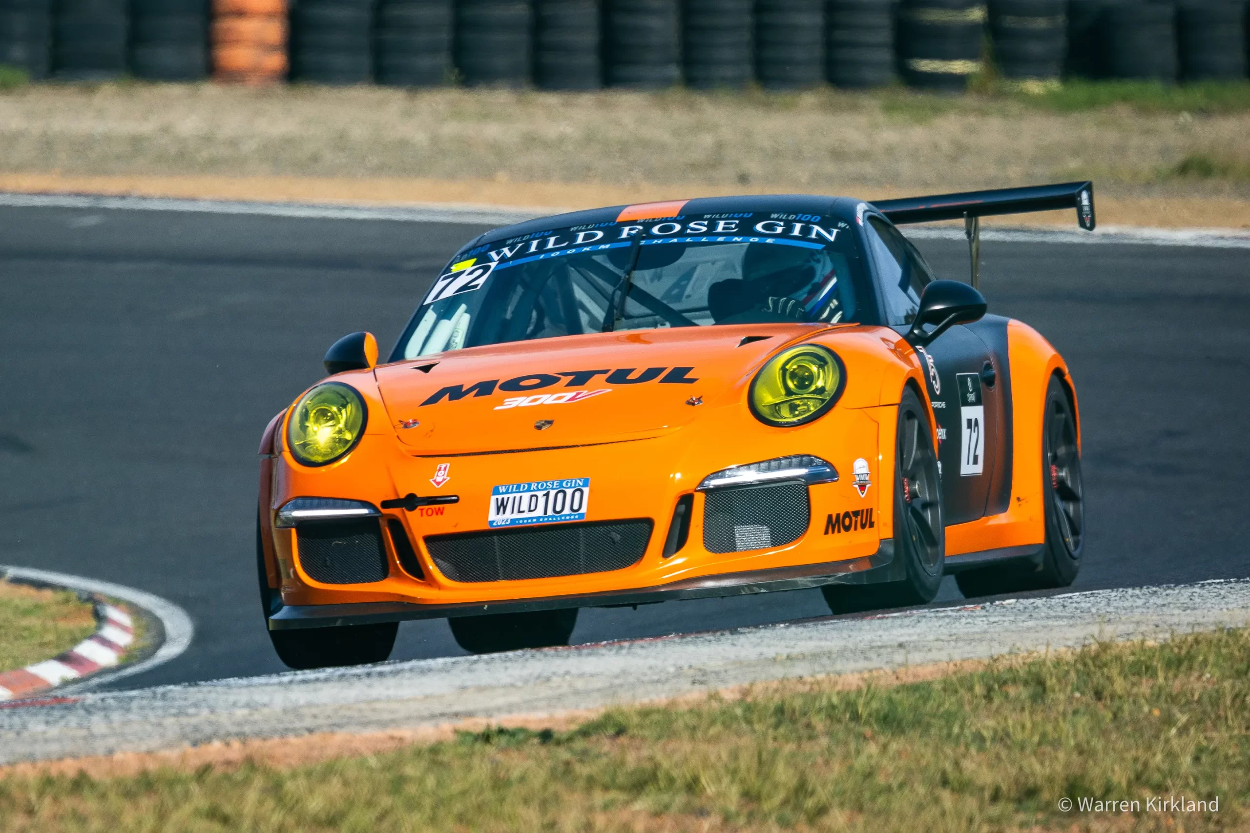 Orange Porsche racing through a corner, Extreme Festival