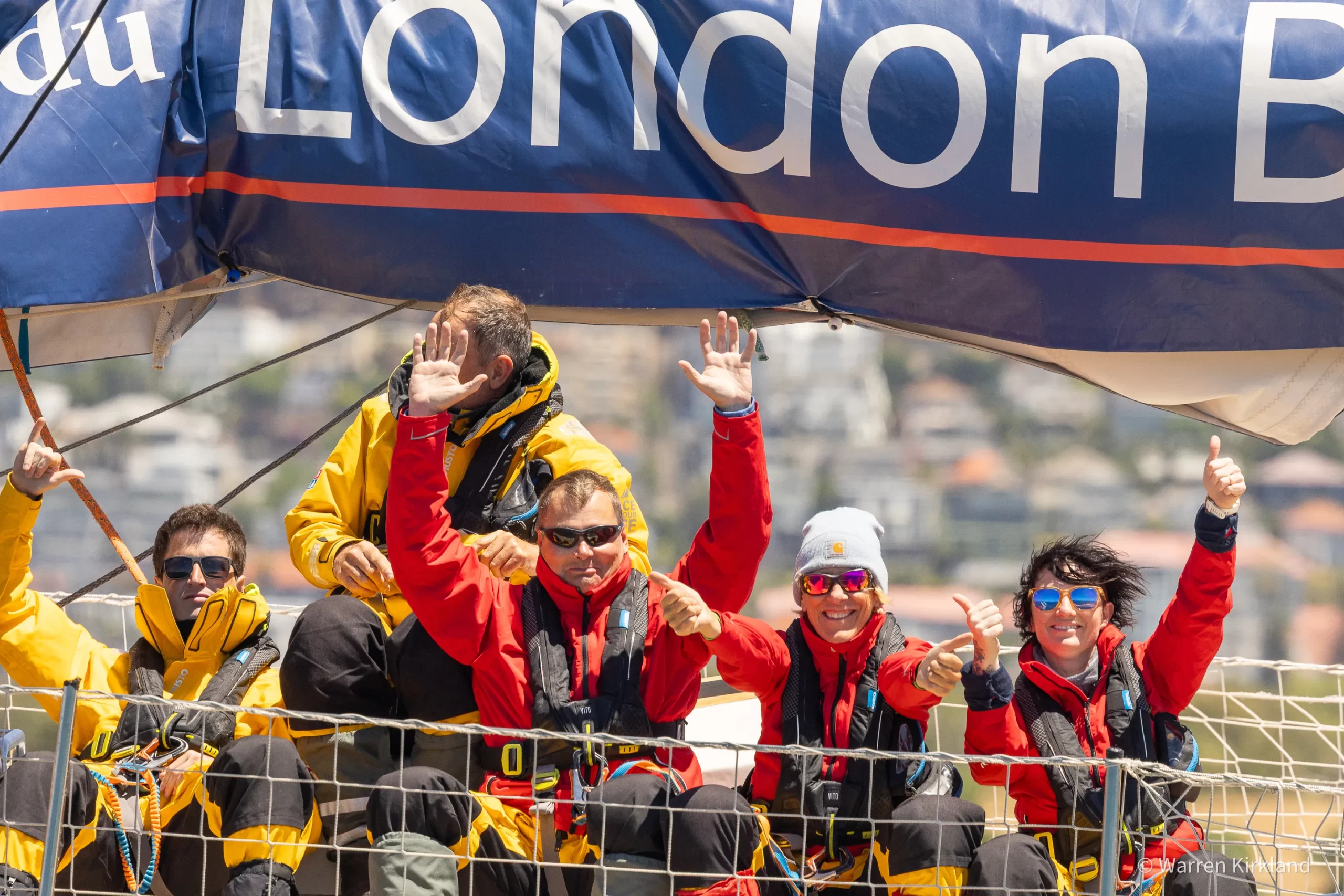 Crew waving from aboard a Clipper Round The World Race yacht