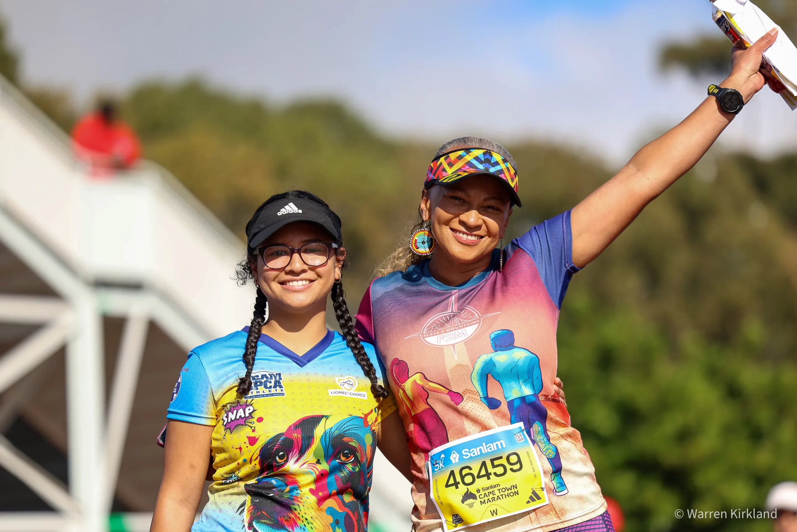Two runners posing together, one waving to the crowd, Cape Town Marathon