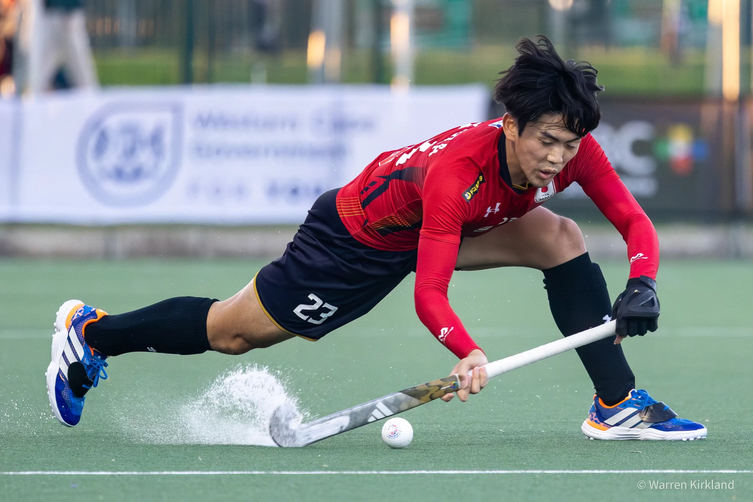 Hockey player diving low to control the ball, FIH Hockey Men's Nations Cup