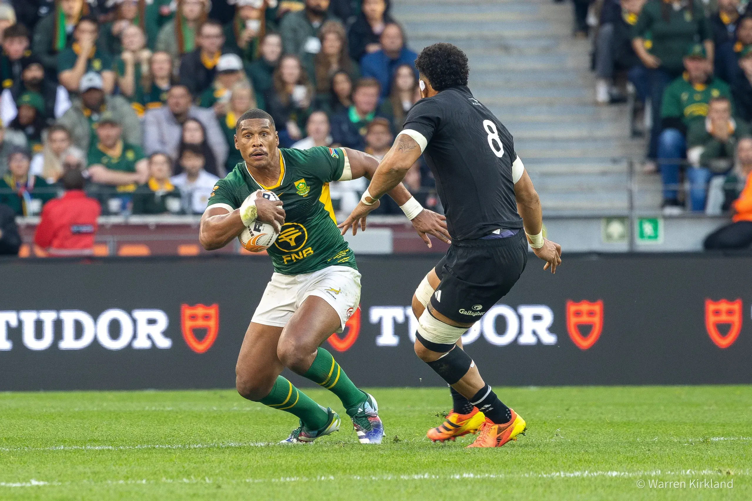 Cape Town sports and event photographer capturing a Springboks player running with the ball and side stepping an All Blacks player, Rugby's Greatest Rivalry Tour - Springboks vs All Blacks